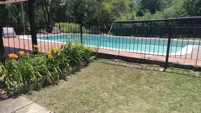 a fence in front of a swimming pool at Cabañas Buen Dia in Villa Serranita