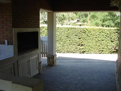 a screened in porch with a television and a hedge at Solar Encantado Cabañas & Chalet in Villa General Belgrano