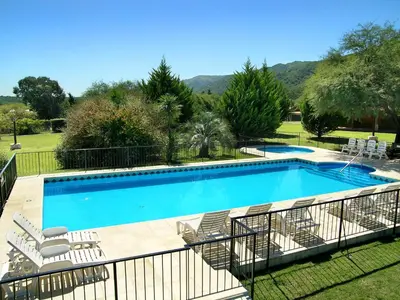 a large swimming pool with a bunch of chairs around it at Solar Encantado Cabañas & Chalet in Villa General Belgrano