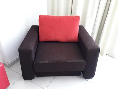 a couch with a red pillow on top of it at Departamento Luxor in Villa Carlos Paz
