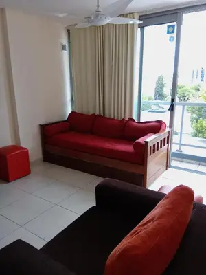 a living room with a red couch in front of a window at Departamento Luxor in Villa Carlos Paz