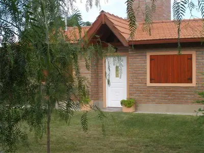 a house with a white door and a red shutter at Cabañas Valentina in Cortaderas