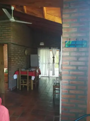 a dining room with a table and a brick wall at Cabañas Valentina in Cortaderas