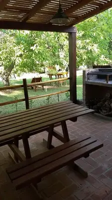 two wooden benches sitting on a patio with a grill at Entre Flores in Los Hornillos