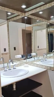 a bathroom with three sinks and two mirrors at La Colina in Villa Carlos Paz
