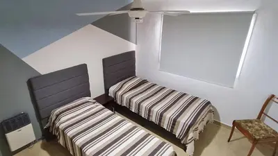 a bedroom with two beds and a ceiling fan at La Colina in Villa Carlos Paz
