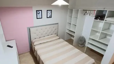a small bedroom with a bed and white shelves at La Colina in Villa Carlos Paz
