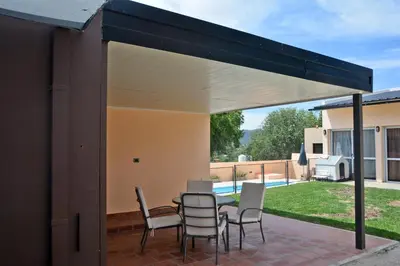 a retractable pavilion with a table and chairs on a patio at La Colina in Villa Carlos Paz
