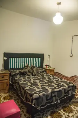 a bedroom with a large bed and two night stands at Feliza Hostel in Villa Carlos Paz