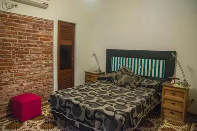 a bedroom with a bed and a brick wall at Feliza Hostel in Villa Carlos Paz