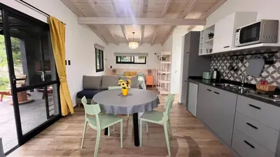 a kitchen and living room with a table and chairs at Cabañas Buena Vista - Santa Rosa in Santa Rosa de Calamuchita