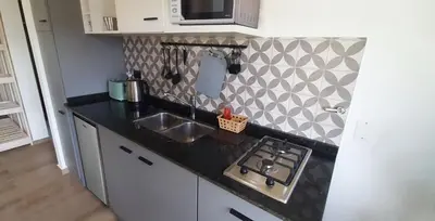 a kitchen counter with a sink and a stove at Cabañas Buena Vista - Santa Rosa in Santa Rosa de Calamuchita