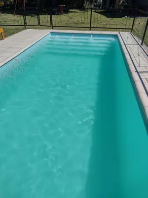 a large pool of blue water in a yard at Cabañas Brisas Del Mirador in Bialet Massé