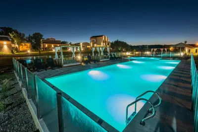 a swimming pool at night with lights on at Sierras Encantadas Cabañas in Panaholma