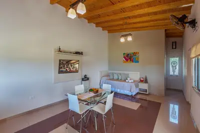 a living room with a table and chairs and a couch at Sierras Encantadas Cabañas in Panaholma