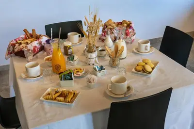 a table with food and cups and plates of pastries at Sierras Encantadas Cabañas in Panaholma