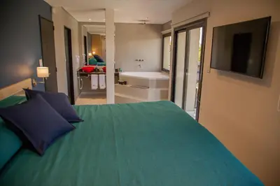 a bedroom with a bed and a bathroom with a tub at Lake Point Residencias in Villa Parque Siquiman