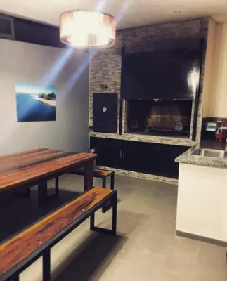a restaurant with two wooden tables and a large tv at Lake Point Residencias in Villa Parque Siquiman