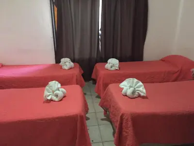 a group of four beds with red sheets and white masseuses at Palmas del Lago in Villa Carlos Paz