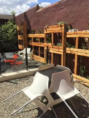 a chair and a table in front of a fence at Palmas del Lago in Villa Carlos Paz