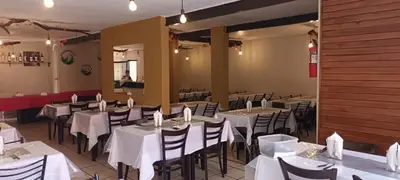 a dining room with white tables and chairs at Palmas del Lago in Villa Carlos Paz