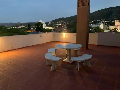 a table and chairs on a roof with a view of a city at Edificio Hipolito Irigoyen in Villa Carlos Paz