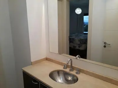 a bathroom with a sink and a large mirror at Edificio Hipolito Irigoyen in Villa Carlos Paz