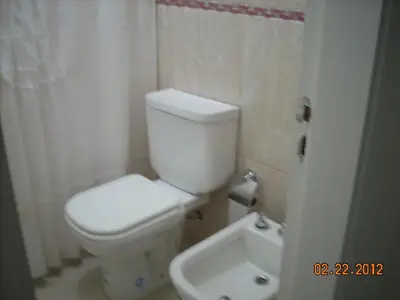 a bathroom with a white toilet and a sink at Edificio Hipolito Irigoyen in Villa Carlos Paz