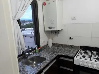 a kitchen with a stove and a sink and a window at Edificio Hipolito Irigoyen in Villa Carlos Paz