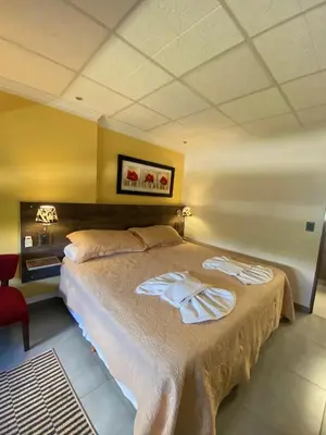 a bedroom with a bed and a red chair at Alto Valle in Nono