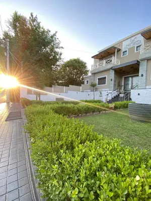 a building with the sun shining behind a hedge at Alto Valle in Nono