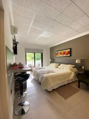 a bedroom with a bed and a desk and a table at Alto Valle in Nono