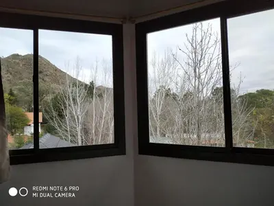 three windows in a room with a view of a mountain at Casas Altas VGB in Villa General Belgrano