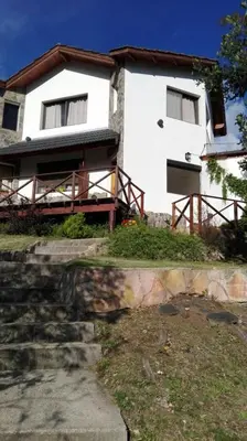 a white house with a staircase in front of it at Casas Altas VGB in Villa General Belgrano