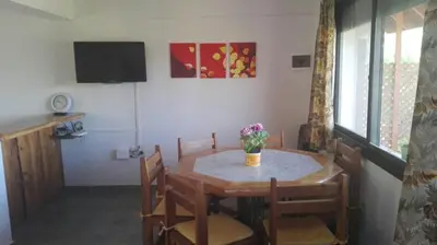 a dining room table with a vase of flowers on it at Casas Altas VGB in Villa General Belgrano