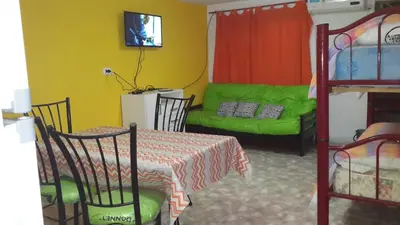 a room with a table and a bed and a couch at Cabañas El Paraiso in Villa Parque Siquiman