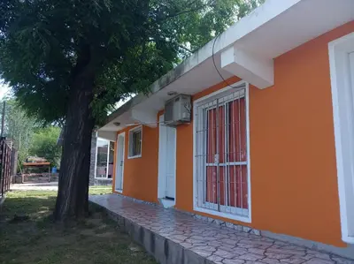 an orange building with a tree next to it at Cabañas El Paraiso in Villa Parque Siquiman