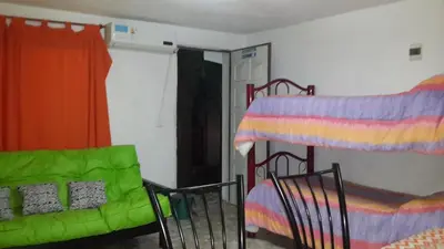a room with a bed and a bed and a couch at Cabañas El Paraiso in Villa Parque Siquiman