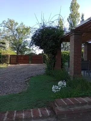 a yard with a house with a fence and flowers at Finca El Amparo in Los Reartes