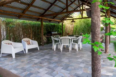 a patio with a table and chairs under a pergola at Finca El Amparo in Los Reartes
