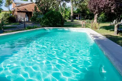 a swimming pool with blue water in a yard at Finca El Amparo in Los Reartes