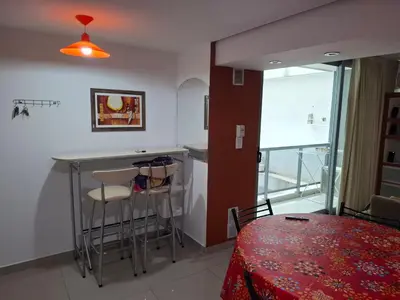 a kitchen with a bar and a table and chairs at Departamento Eutico in Villa Carlos Paz