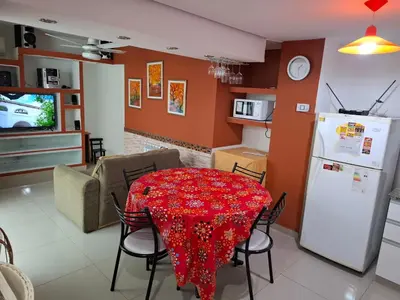 a kitchen and living room with a table and a refrigerator at Departamento Eutico in Villa Carlos Paz