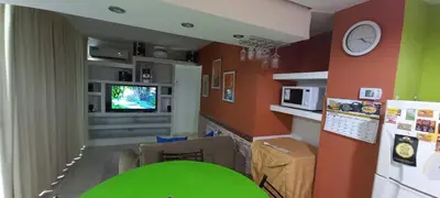 a kitchen with a green table and a clock on a wall at Departamento Eutico in Villa Carlos Paz