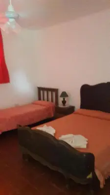 a bedroom with two beds and a table with a lamp at El Cortijo de la villa in Villa Independencia