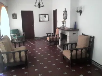 a living room with chairs and a fireplace at El Cortijo de la villa in Villa Independencia