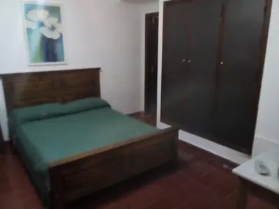 a bedroom with a bed and a dresser in it at El Cortijo de la villa in Villa Independencia