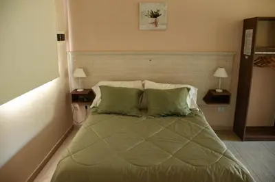 a bedroom with a large bed with green pillows at La Catalina Traslasierra in Nono