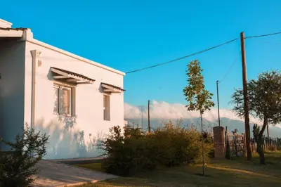 a white house with mountains in the background at La Catalina Traslasierra in Nono