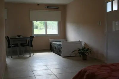 a room with a bed and a table and a window at La Catalina Traslasierra in Nono